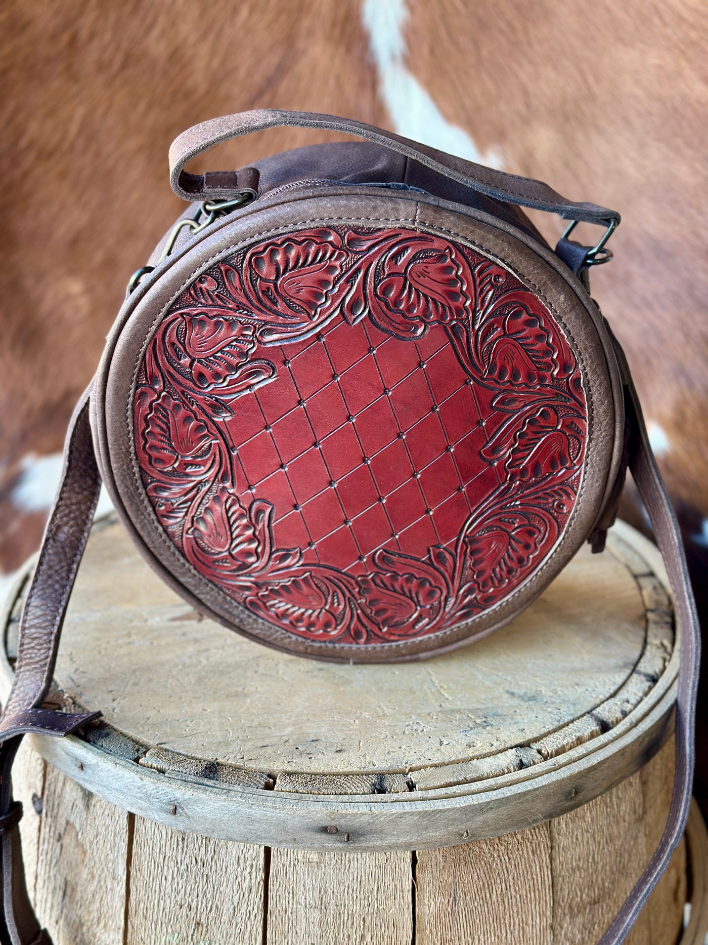 Round Leather Crossbody Bag, hand-tooled design, and Adjustable Strap.