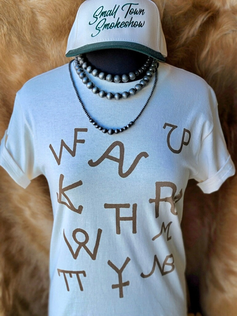 Cowgirl-inspired Western tee with vintage cattle brand design styled with Navajo Pearls and a trending ballcap.