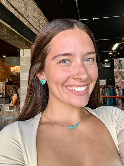 Harvard Turquoise Teardrop Stud Earrings featuring unique marbled faux turquoise stones in a classic setting, modeled by Broker Leather Employee, Aubree.