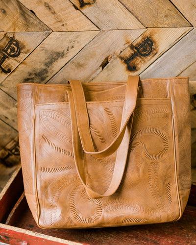 Western-style genuine leather tote bag with intricate tooling and spacious interior.