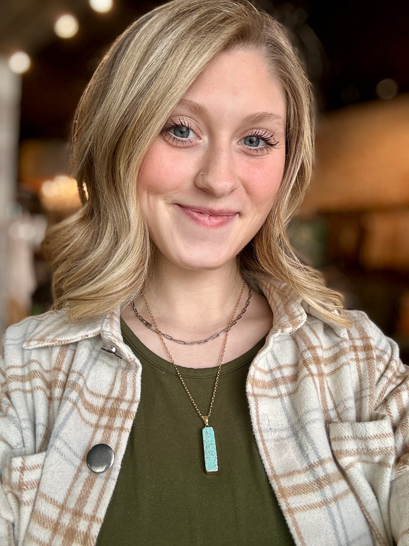 Hershey Faux Turquoise Bar Necklace styled with layered gold chains on Broker Leather model, Grace.