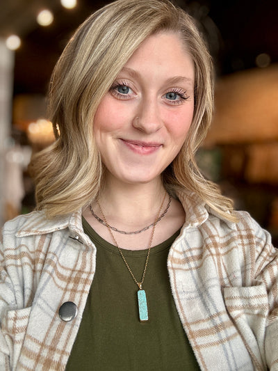 Hershey Faux Turquoise Bar Necklace styled with layered gold chains on Broker Leather model, Grace.