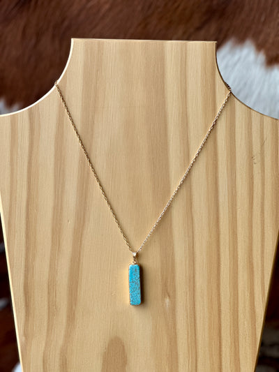 Hershey Faux Turquoise Bar Necklace displayed as a statement piece on a rustic wooden background.