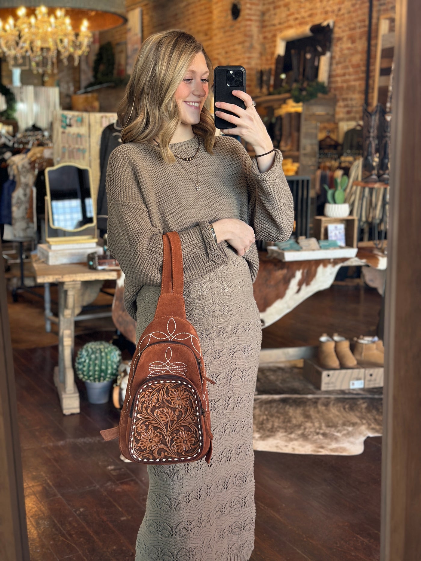 Western Suede Leather Backpack in Rust with Whipstitch Detailing held by model to show size relevance.