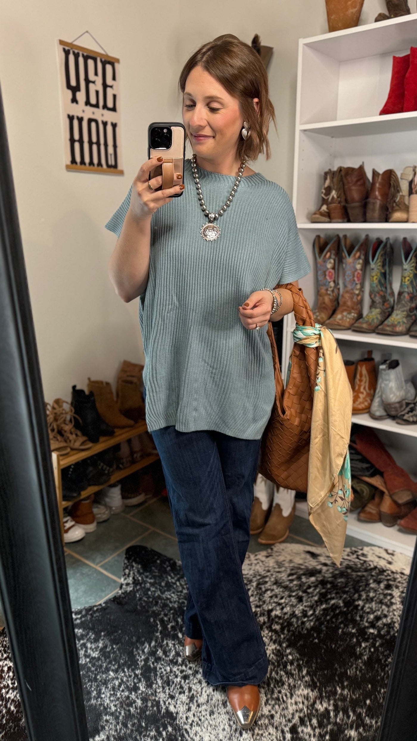 Model wearing Holland sweater with jeans and pearl necklace.
