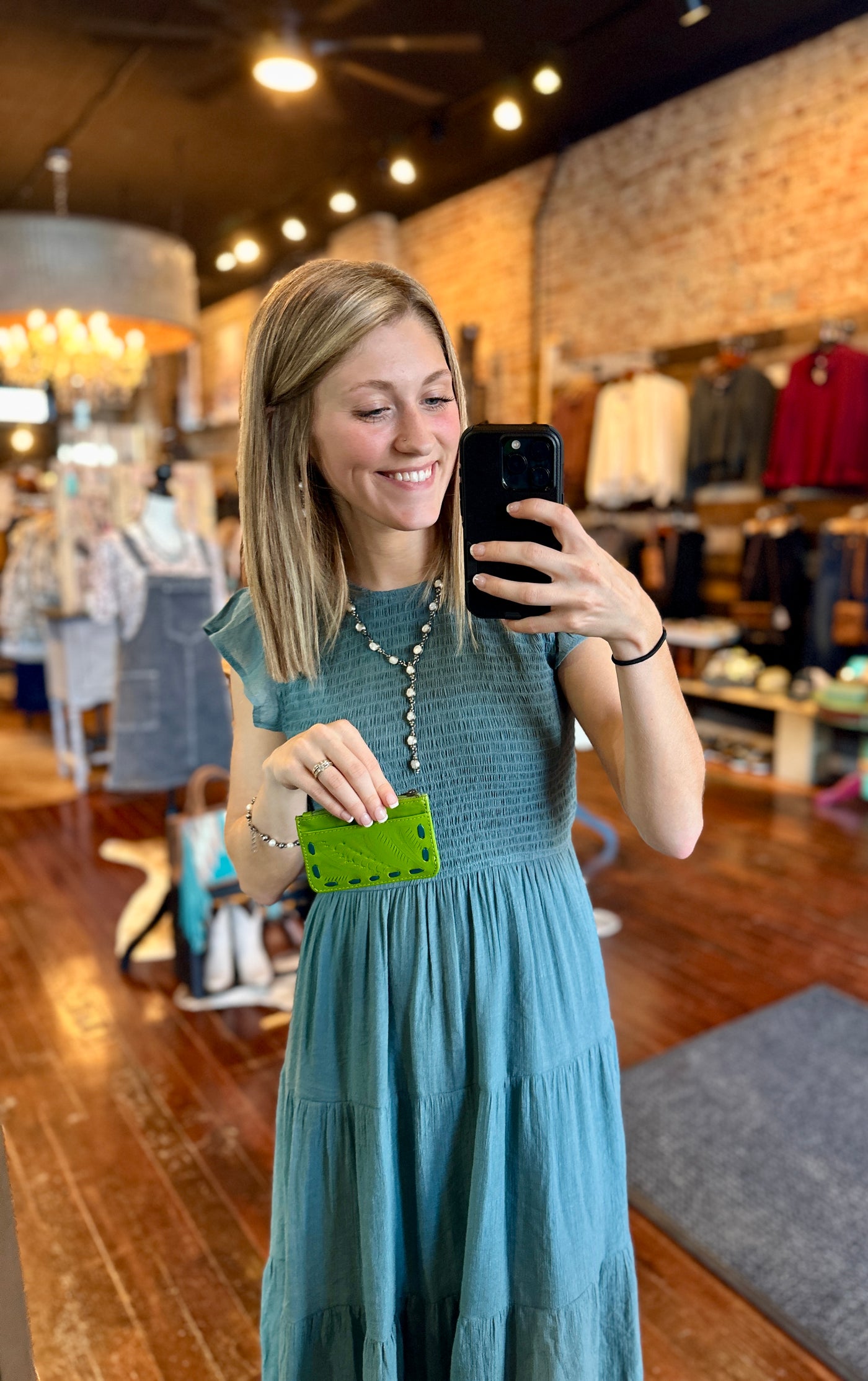 Stylish and practical Jackson Card + Coin Pouch [Green], a timeless classic modeled by Broker Leather employee, Grace, for size reference.