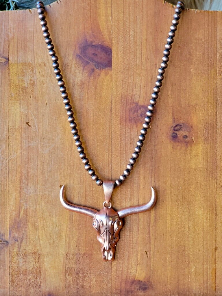 Longhorn skull and Navajo pearl necklace in warm copper tones for true western grit.