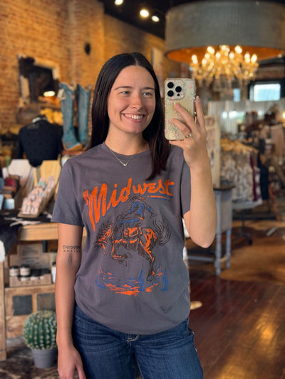 A Broker Leather employee modeling the Jenel Midwest Rodeo Graphic Tee featuring a cowboy riding a bucking horse.