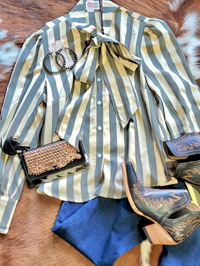 Flatlay of the western-inspired striped blouse with bowtie detail paired with Ariat Dixons, Trousers, & Navajo Pearl Earrings.