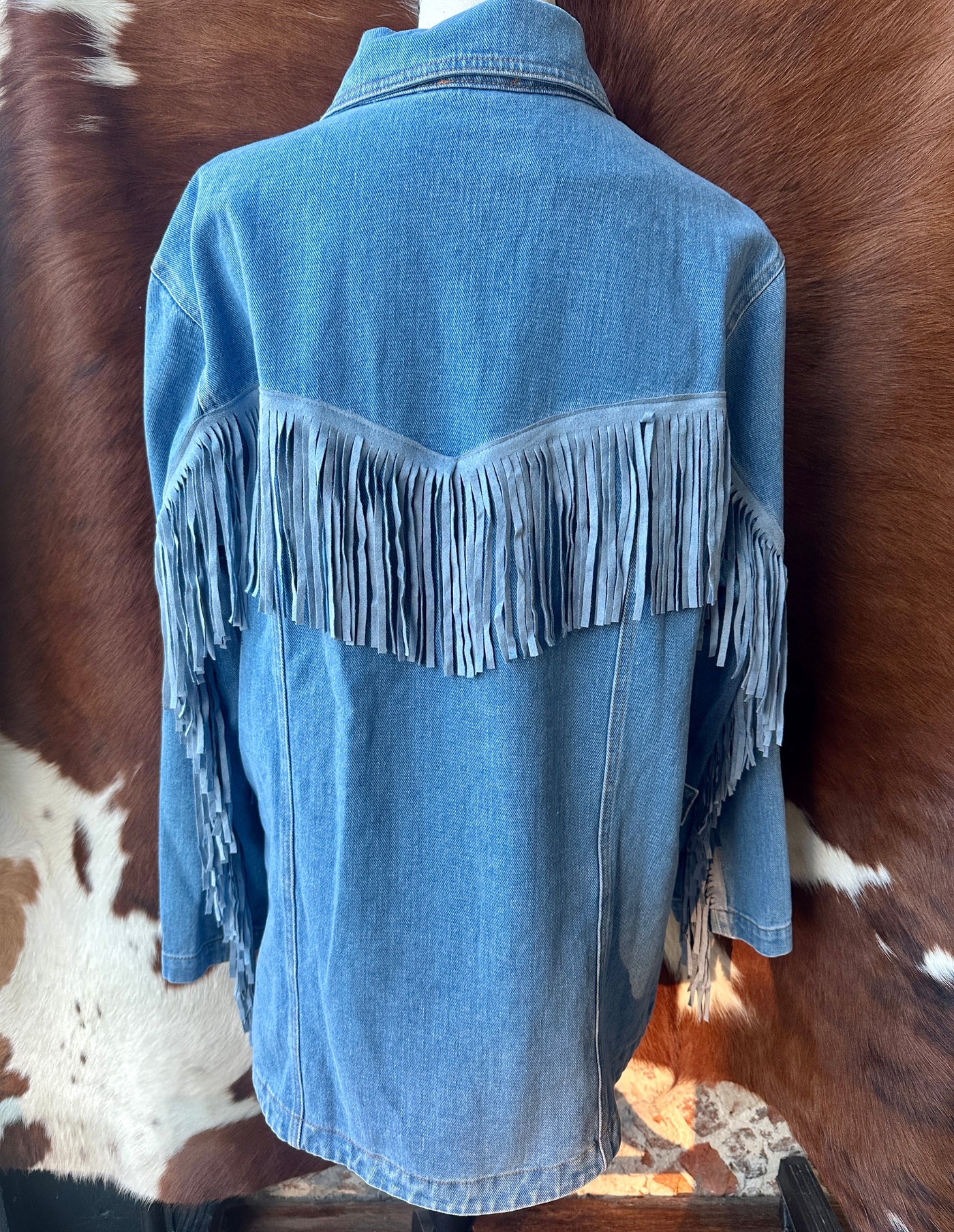 Back View of Denim Jacket with Bold Western Fringe Detailing.