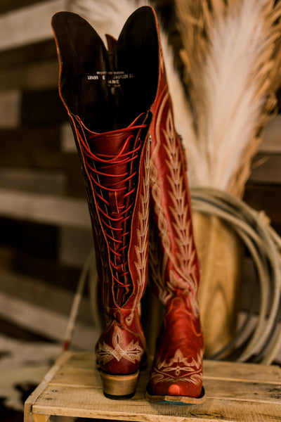 Ruby red over-the-knee Lane Lexington boots featuring a snip toe and functional laced corset back to accommodate thicker calves.