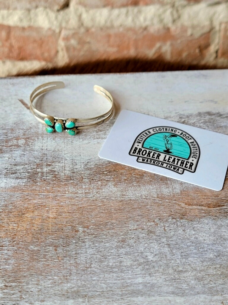 Heirloom-Quality Sterling Silver Cuff Bracelet with Authentic Turquoise photographed next to a plastic gift card for size reference.