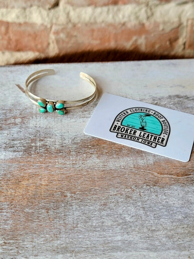 Heirloom-Quality Sterling Silver Cuff Bracelet with Authentic Turquoise photographed next to a plastic gift card for size reference.