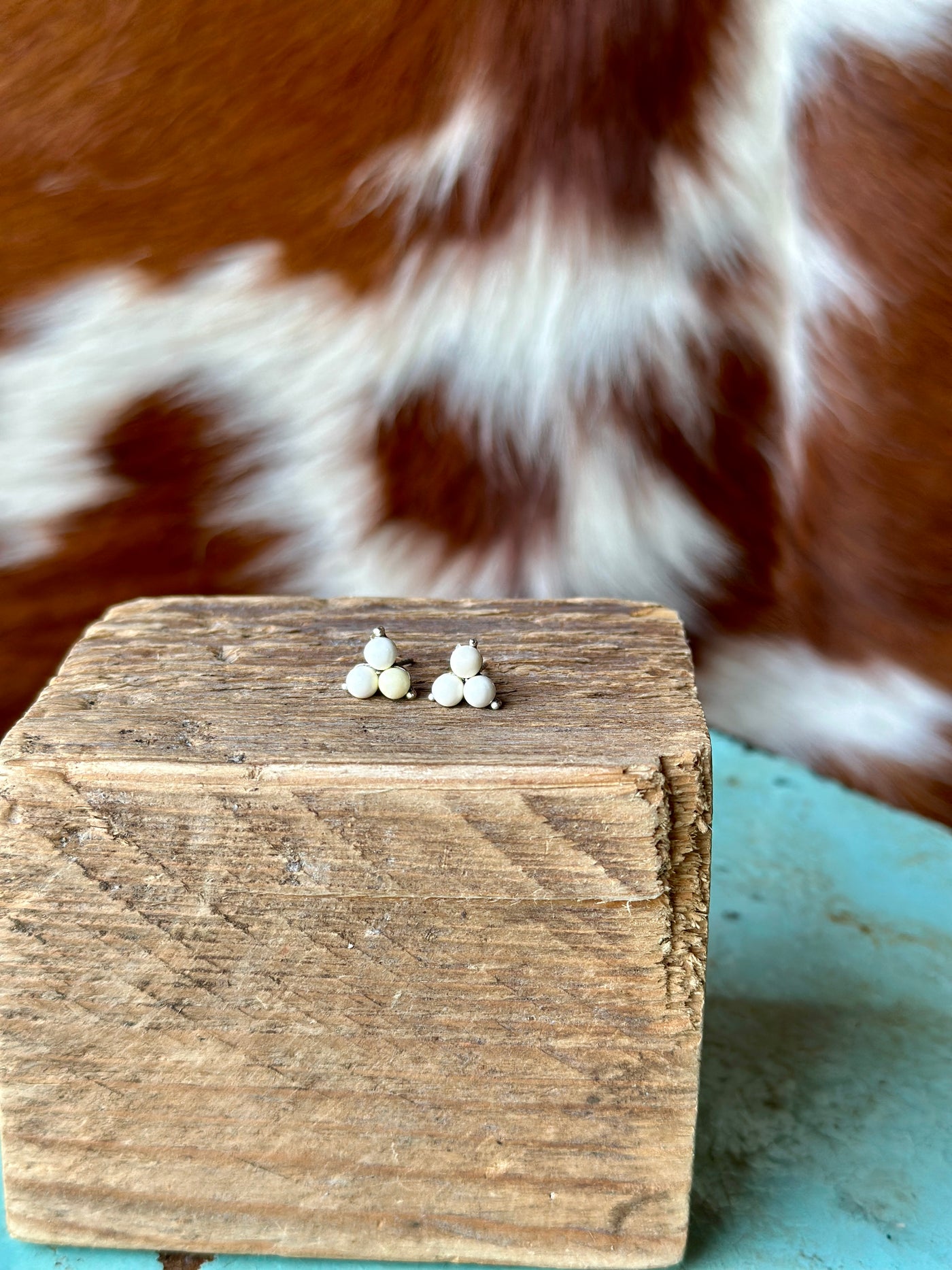 Close-up of Laura White Turquoise Stud Earrings featuring faux turquoise stones with a smooth, polished surface set in antique silver plate.