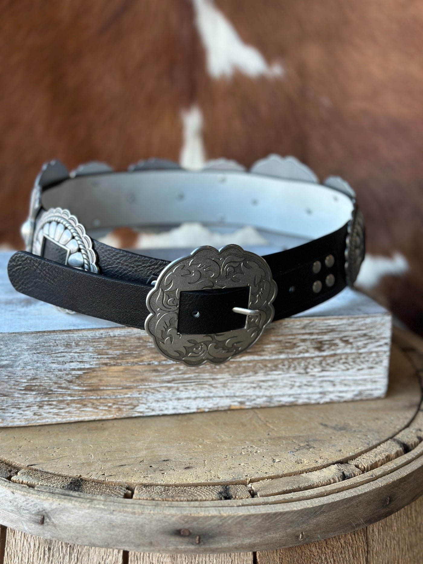 Stylish black leather belt with removable silver conchos.