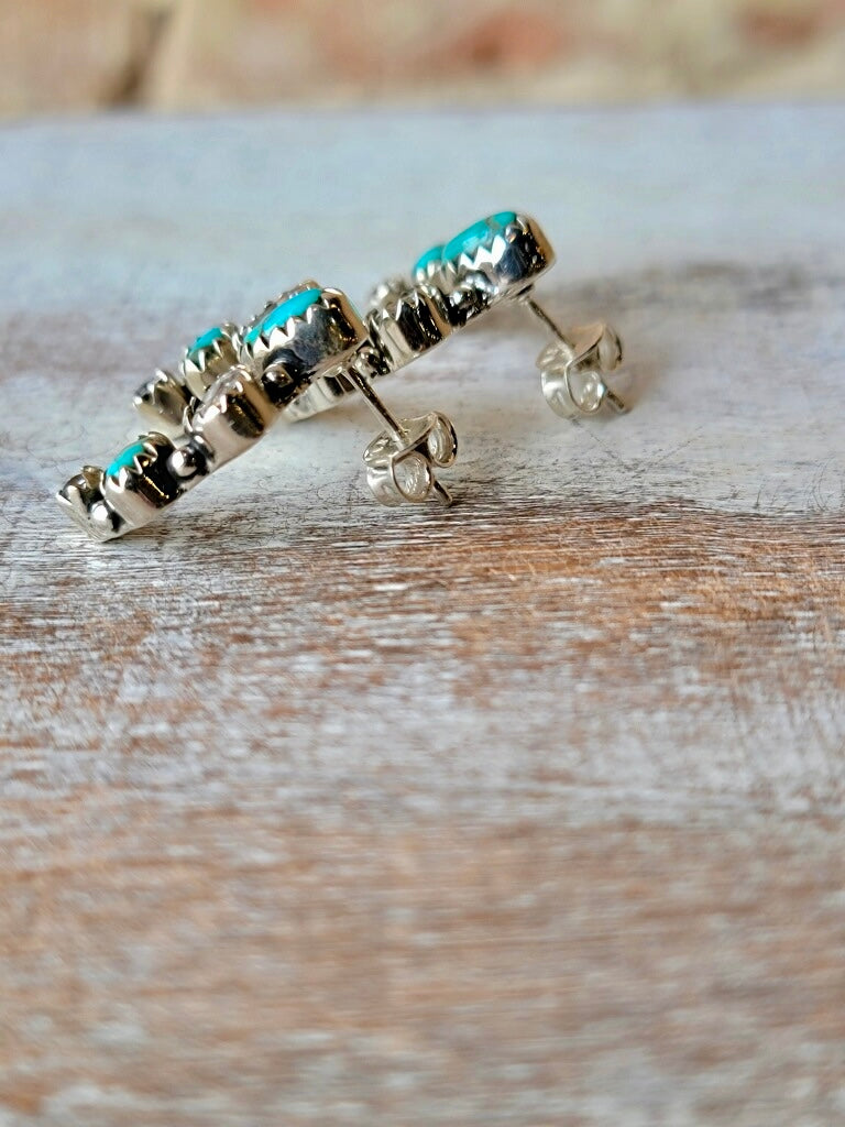 Lovella Squash Blossom Earrings Displayed Against a Rustic Background showing post position.