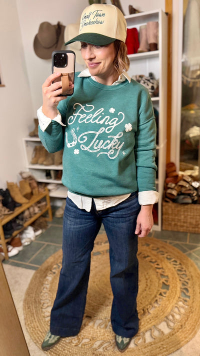 Model Wearing Lucky Graphic Sweatshirt with denim jeans, boots, and a the Cassandra small town smokeshow hat for a Casual Look.