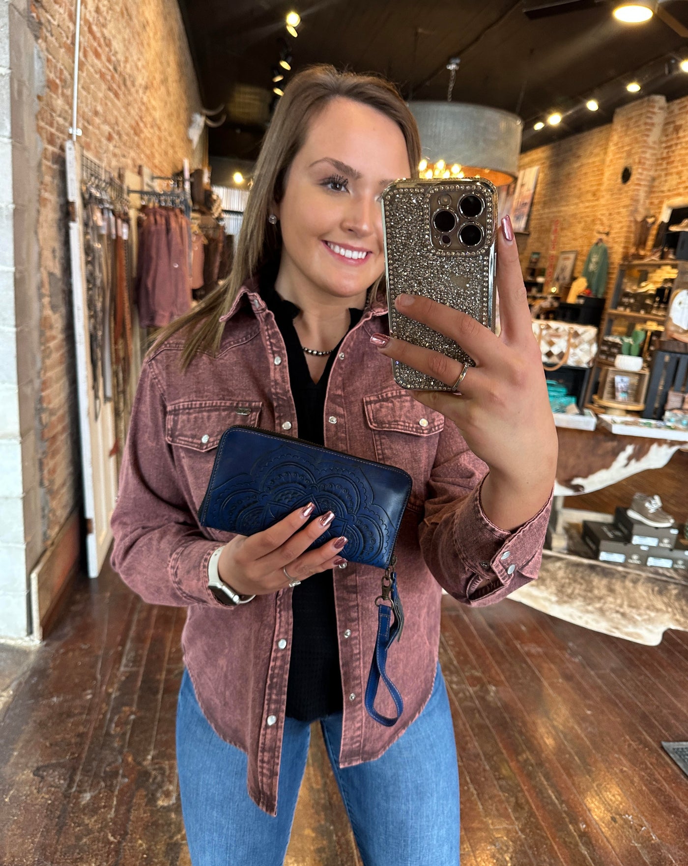 Broker Leather's employee, Gracelyn, modeling the Madison Tooled Leather Mandala Organized Wristlet [Deep Blue] for size reference.