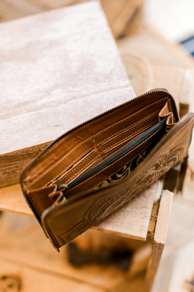 Interior of tooled leather wristlet with 12 card slots, cash compartments, and coin pocket.