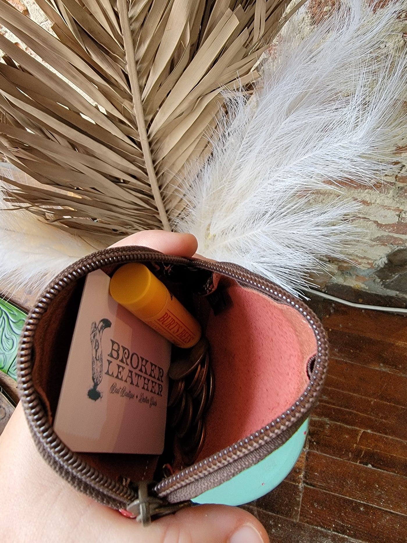 Close-up of Maisy Round Leather Coin Pouch, showing gift card and chapstick inside zip closure for size reference.