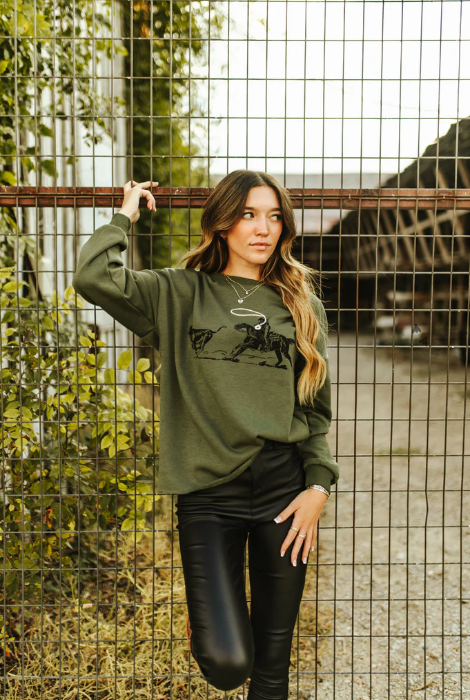 Cozy olive green sweatshirt styled with leather leggings for a modern Western look.