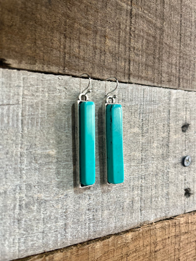 Side view of the earrings highlighting the faux turquoise details with unique color and marbling variations.