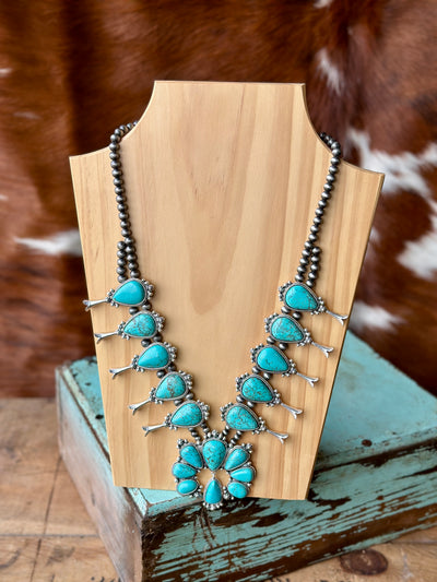 Close-up of the Marty Turquoise Squash Blossom Necklace showcasing bold turquoise stones in a timeless Western style.