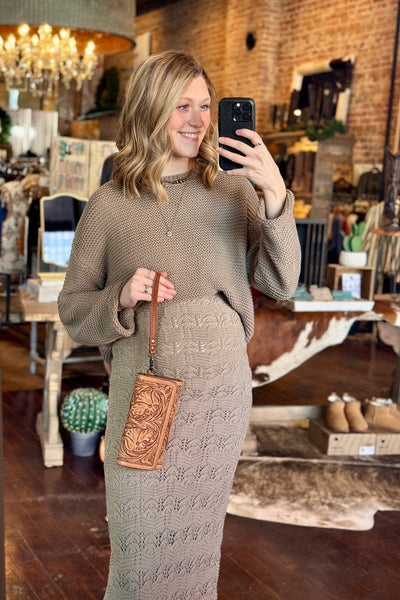 Broker Leather model holding the Matilda Tooled Leather Wallet with 10 Credit Card Slots and Cash Storage to show the size.