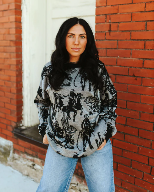 Model wearing Mayfield Metallic Knit Sweater with relaxed silhouette and cowboy-themed designs.