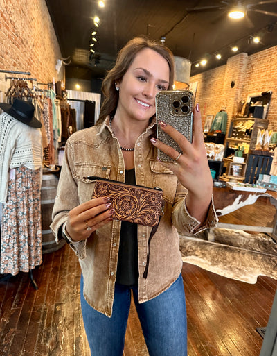 McKenna Tooled Leather Wristlet – vintage-style small wallet with floral tooling and zip closure held by model for size relevance.