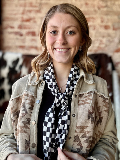 Black and white checkered wild rag tied in a cowboy-style 4-square knot.