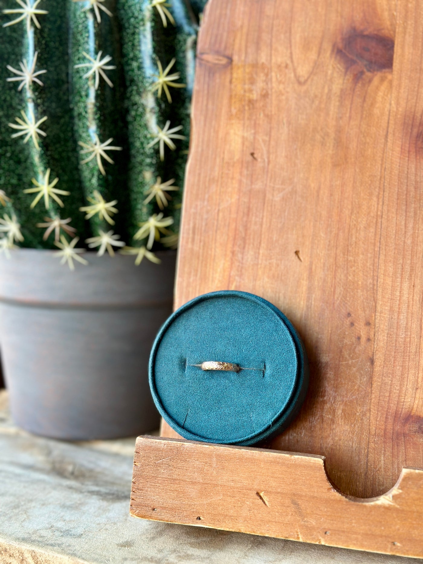 
The Moana Floral Gold Stacker Ring showing intricate engraved details in a jewelry box for relative size comparison.