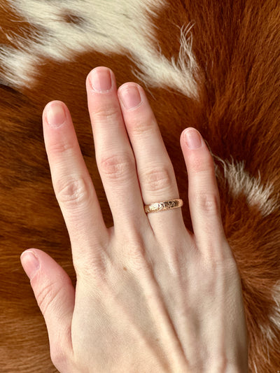 Delicate gold ring with floral tooling design, inspired by saddle leather craftsmanship.