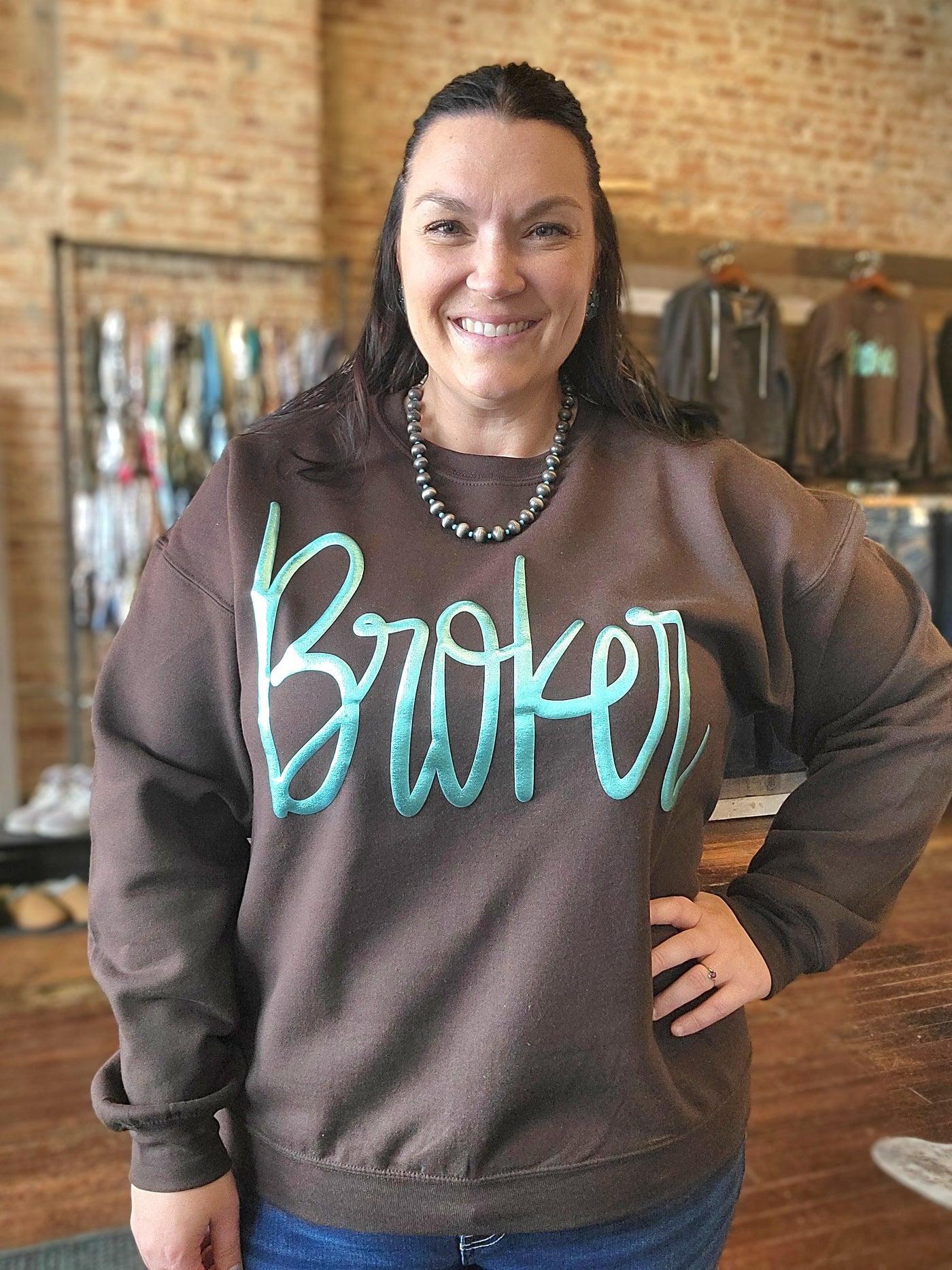 A custom crewneck for Broker Leather featuring the Barbie font in a light turquoise puff paint.