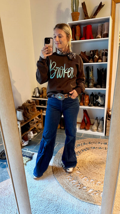 A Broker Leather employee modeling the custom crewneck with Barbie front reading "Broker."