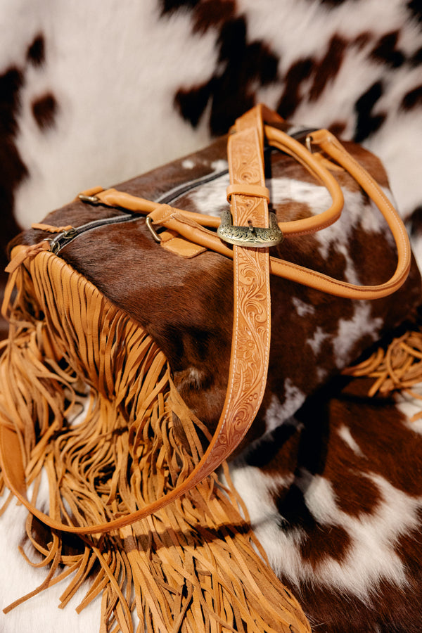 Bold cowgirl fashion duffel bag with long leather fringe detailing that you find at Broker Leather.