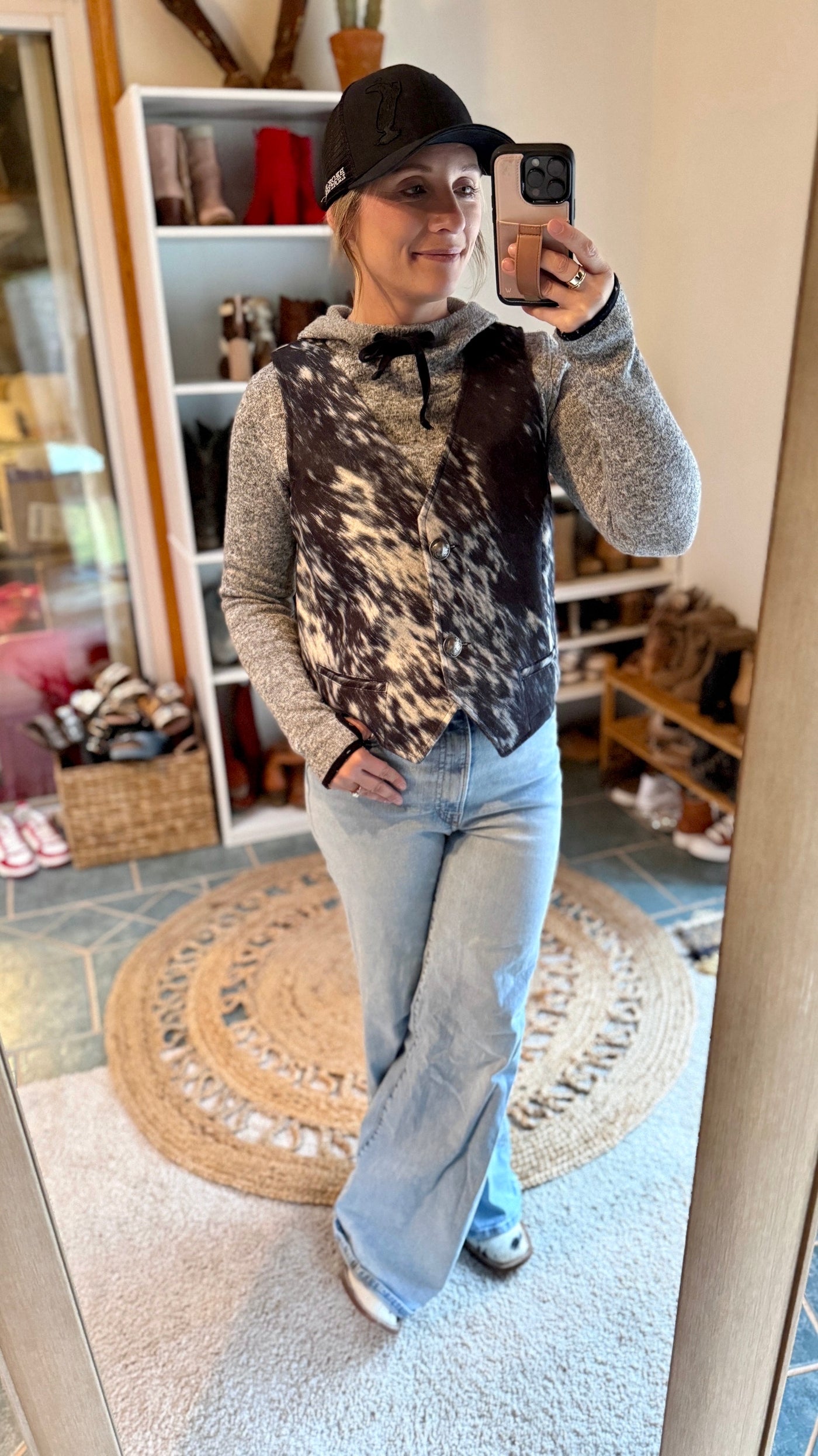 Model wearing the Open Gate S&P Cowhide Vest styled with a casual hoodie and jeans outfit and ballcap.