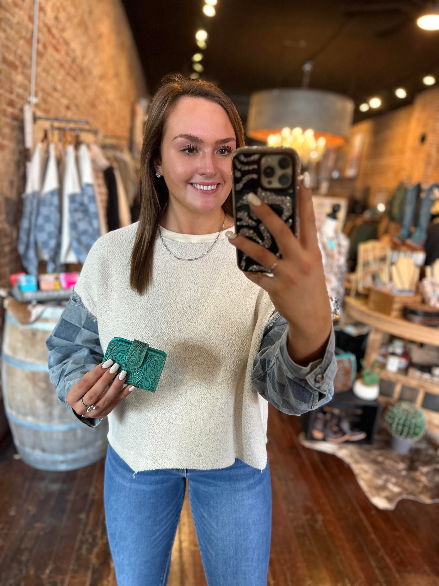 Broker Leather employee modeling our our turquoise Patricia Tooled Leather Cardholder Wallet to show size.