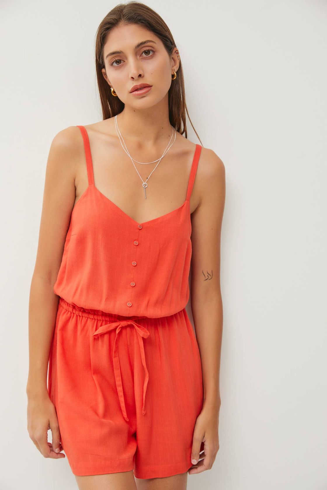 But show me just this one thing, my darling, I seek a heart stained like a poppy flower.’ - Fatima Bhutto. Model wearing the Poppy V-Neck Drawstring Waist Romper, inspired by the vibrant poppy.