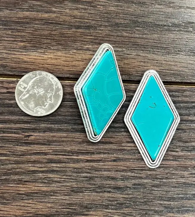 Stock photo of our Reed Turquoise Diamond Post Earrings next to a quarter to show size reference.