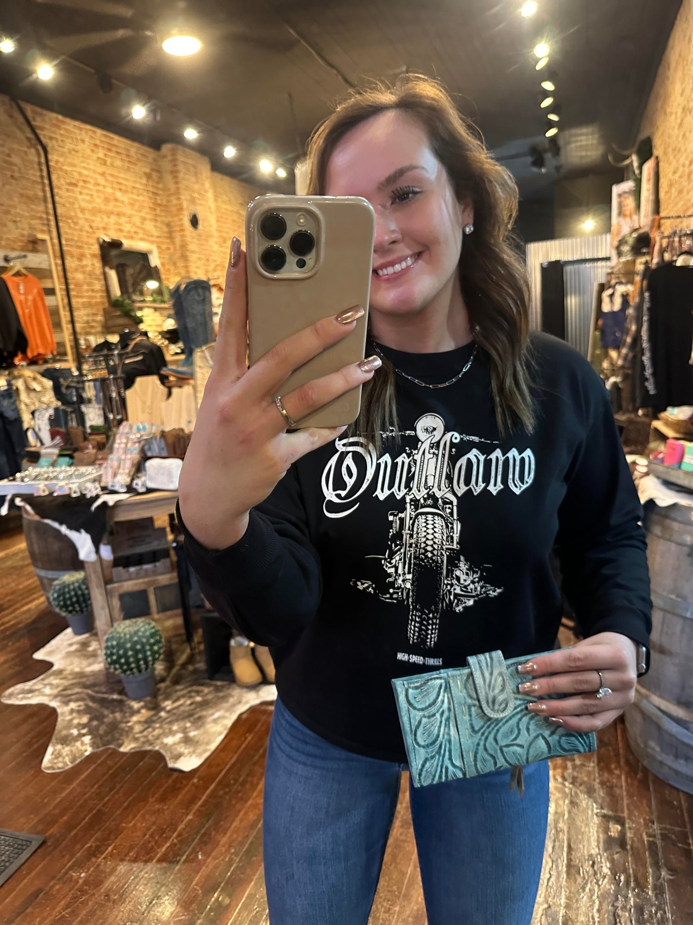 A Broker Leather employee modeling the Ricardo Wallet to show the size; it measures Approx. 7.75" x 4.25".