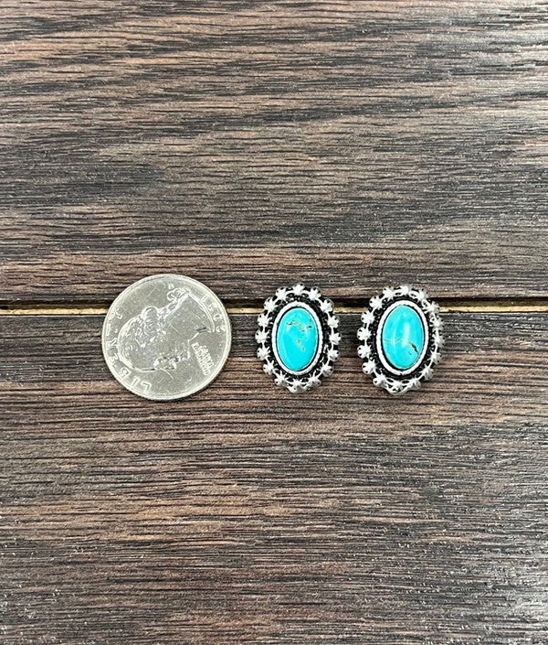 View of the earrings next to a quarter for size comparison highlighting their 0.8" length and oval turquoise stones.