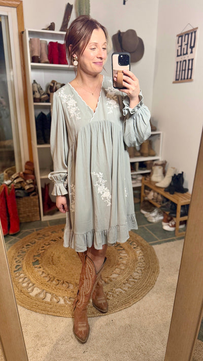 Graceful sage green dress styled with cowboy boots for a Western-inspired look.