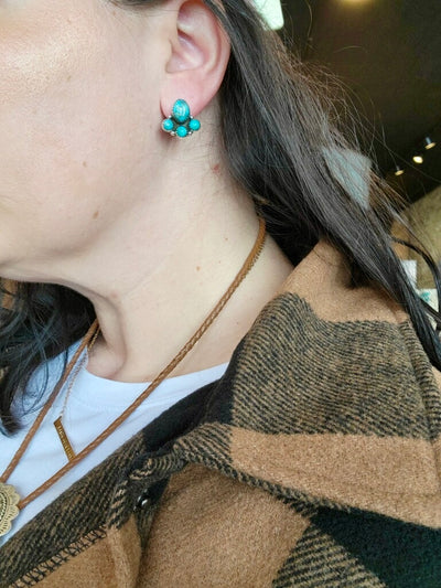 Playful Puppy Paw Print-Inspired Turquoise Earrings in Sterling Silver modeled by a Broker Leather employee.