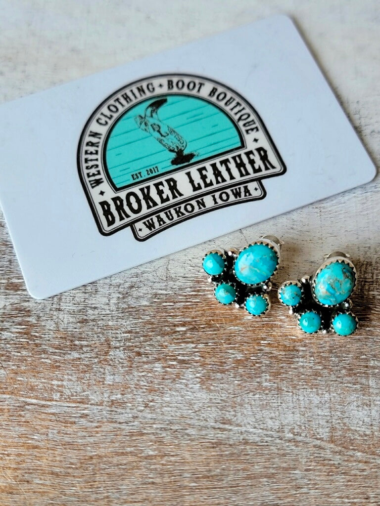 Western-Inspired Turquoise Stud Earrings with Paw Print Shape photographed next to a plastic gift card for size relevance.