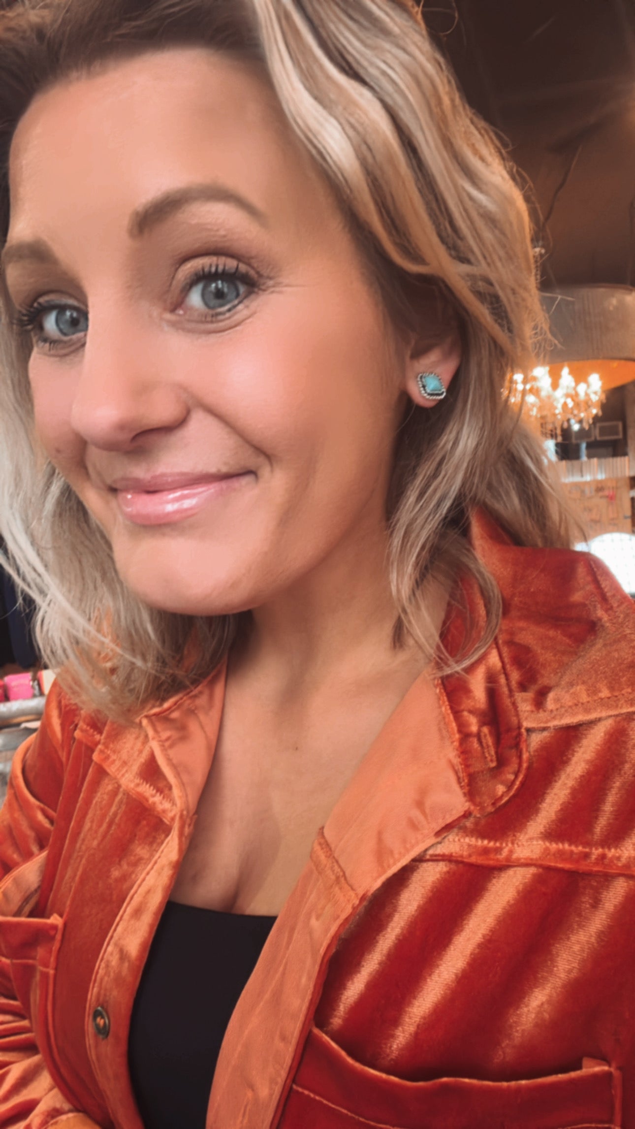 Western and bohemian-style turquoise earrings paired with a casual velvet button down.