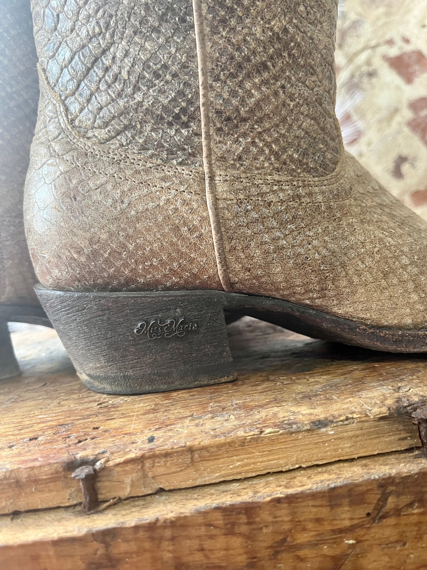 Side view of the Miss Macie Eden Boots highlighting their metal charm on the side of the heel.