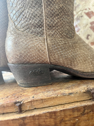 Side view of the Miss Macie Eden Boots highlighting their metal charm on the side of the heel.