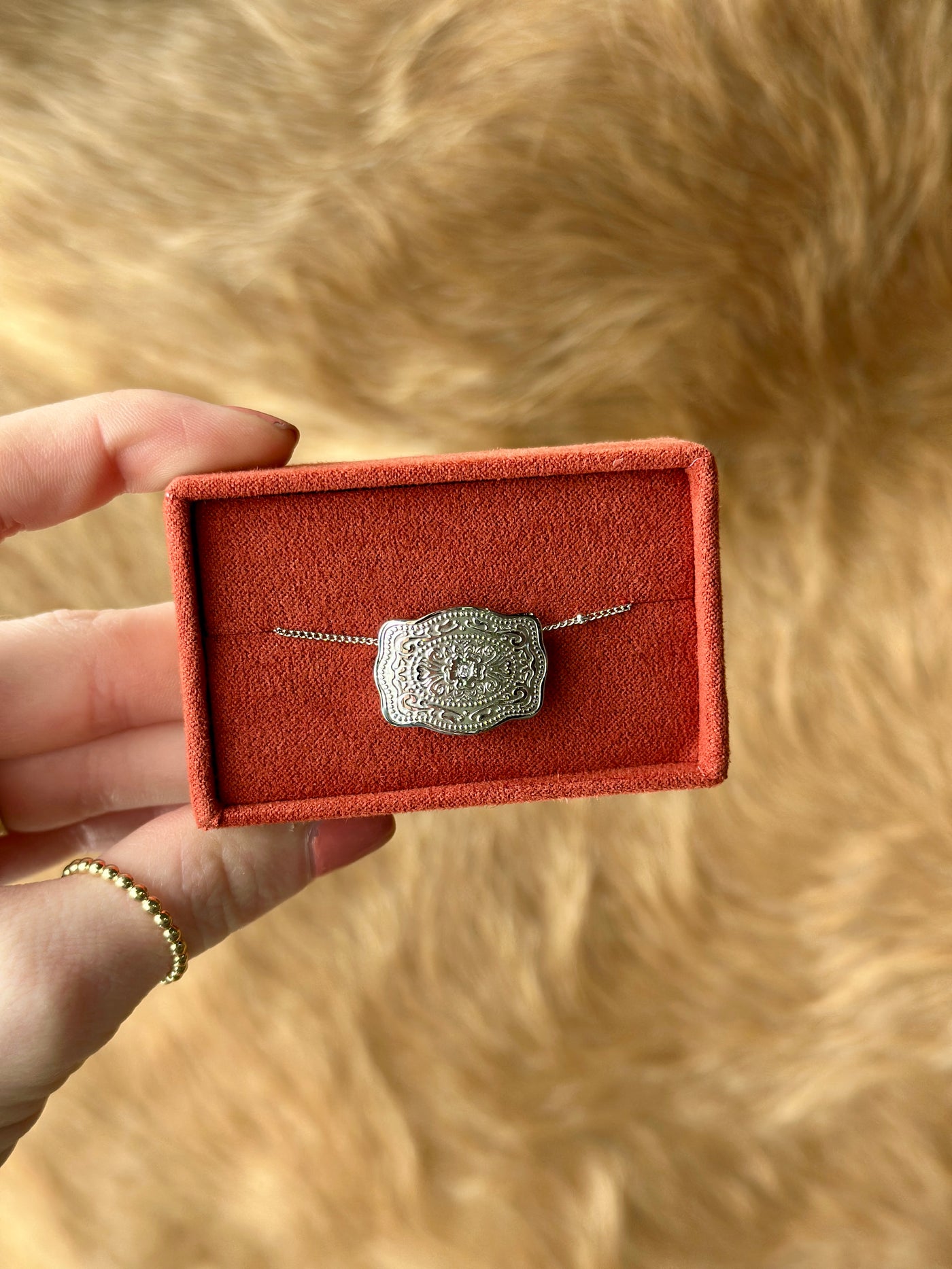 Close-up of silver belt buckle pendant – rustic yet refined cowgirl accessory