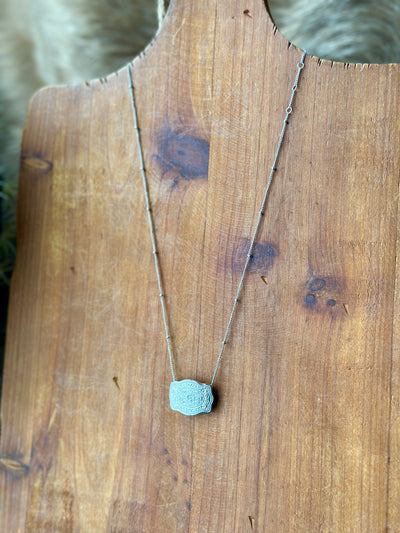 Layered necklace style featuring silver belt buckle pendant – cowgirl chic